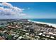 Stunning aerial view showcasing the beautiful coastline, white sandy beach, and vibrant city skyline at 4307 Camino Real, Sarasota, FL 34231
