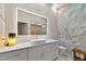 Modern bathroom featuring marble wall, lighted mirror, white vanity and vessel sink at 4307 Camino Real, Sarasota, FL 34231