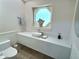Updated powder room with floating quartz countertop and octagon window at 4307 Camino Real, Sarasota, FL 34231