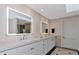 Bright bathroom with a double vanity, illuminated mirrors, and modern fixtures at 4307 Camino Real, Sarasota, FL 34231