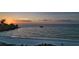Calm beach view at sunset with gentle waves, a boat out on the water, and chairs on the sand at 4307 Camino Real, Sarasota, FL 34231