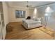 Spacious bedroom with tray ceilings, light walls, hardwood floors, ceiling fan and chest at 4307 Camino Real, Sarasota, FL 34231