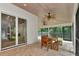 This screened in dining area with ceiling fans and a view to the backyard is perfect for entertaining at 4307 Camino Real, Sarasota, FL 34231