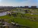 Picturesque aerial view of a lush golf course with serene ponds, palm trees and waterfront condos at 4307 Camino Real, Sarasota, FL 34231