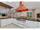 Modern kitchen featuring an expansive range, an oven, and an eye-catching copper exhaust hood at 4307 Camino Real, Sarasota, FL 34231