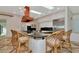 A view of the kitchen island and copper range hood with chairs for a relaxed meal at 4307 Camino Real, Sarasota, FL 34231