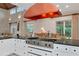 Modern kitchen with island, chef's oven and range, and a copper exhaust hood at 4307 Camino Real, Sarasota, FL 34231
