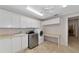 Functional laundry room with modern appliances, countertop and storage cabinets at 4307 Camino Real, Sarasota, FL 34231