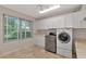 Bright laundry room features a large window and a modern washer and dryer at 4307 Camino Real, Sarasota, FL 34231