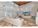 A living room with bright white walls, vaulted wood ceilings and a large sectional sofa at 4307 Camino Real, Sarasota, FL 34231