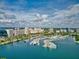 Aerial view of a marina filled with yachts, set against a city skyline and sparkling blue water at 4307 Camino Real, Sarasota, FL 34231