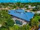 An aerial view of the house's rear exterior, with a screened pool, patio and landscaping at 4307 Camino Real, Sarasota, FL 34231