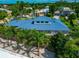 An aerial view of the house's rear exterior, with a blue roof, backyard and landscaping at 4307 Camino Real, Sarasota, FL 34231