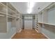 Spacious walk-in closet with custom shelving, drawers and wood flooring at 4307 Camino Real, Sarasota, FL 34231