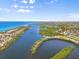 An aerial view showcasing the property's waterfront location between two bodies of water, under a blue sky at 4717 Lemon Bay Dr, Venice, FL 34293