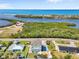 Aerial view of a coastal home with a pool near the beach and bay with lush greenery at 4717 Lemon Bay Dr, Venice, FL 34293