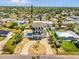 Aerial view of a charming home with a pool, driveway, and mature landscaping in a friendly neighborhood at 4717 Lemon Bay Dr, Venice, FL 34293