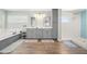 Bathroom with dual vanities, tub, walk-in shower, and wood look flooring at 4717 Lemon Bay Dr, Venice, FL 34293