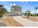 Beautiful three-story home with a spacious driveway, balconies, and mature palms at 4717 Lemon Bay Dr, Venice, FL 34293