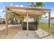 Outdoor hot tub in a covered patio area with lights, barbecue in the background, set in a backyard at 4717 Lemon Bay Dr, Venice, FL 34293
