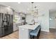 Modern kitchen with gray cabinets, stainless steel appliances, quartz countertops, and island with seating at 4717 Lemon Bay Dr, Venice, FL 34293