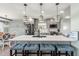 Modern kitchen with gray cabinetry, stainless steel appliances, a large quartz island, and stylish pendant lighting at 4717 Lemon Bay Dr, Venice, FL 34293