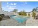 Backyard swimming pool with a stone patio, lounge chairs, and a lush green garden at 4717 Lemon Bay Dr, Venice, FL 34293