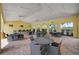 A covered outdoor community area with tables, chairs, and beautiful greenery and shade trees at 5282 Grove Mill Loop, Bradenton, FL 34211
