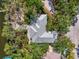Aerial view of a home with gray roof, nestled amongst green trees, surrounded by lush landscaping at 5377 Palos Verdes Dr, Sarasota, FL 34231