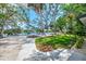 Scenic backyard showcasing lush landscaping, waterfront views and a charming deck with lounge seating at 5377 Palos Verdes Dr, Sarasota, FL 34231