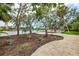 Scenic backyard featuring tropical landscaping, waterfront views, and a wooden deck with lounge seating at 5377 Palos Verdes Dr, Sarasota, FL 34231