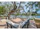 Scenic backyard overlooking the water featuring a wooden deck with lounge seating, and mature trees at 5377 Palos Verdes Dr, Sarasota, FL 34231