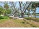 Scenic backyard overlooking the water featuring a wooden deck with lounge seating and shade trees at 5377 Palos Verdes Dr, Sarasota, FL 34231