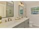 Well-lit bathroom with double sink vanity, quartz countertops, and decorative framed mirrors at 5377 Palos Verdes Dr, Sarasota, FL 34231