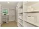 Spacious walk-in closet with custom shelving offers ample storage with a window allowing natural light at 5377 Palos Verdes Dr, Sarasota, FL 34231