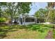 Charming single-story home with lush lawn, screened porch, and mature trees at 5377 Palos Verdes Dr, Sarasota, FL 34231