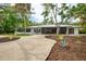Charming single-story home with lush landscaping, a long circular driveway, and a screened-in lanai at 5377 Palos Verdes Dr, Sarasota, FL 34231