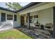 Inviting front porch with stylish slate flooring, black trim, seating, and charming curb appeal at 5377 Palos Verdes Dr, Sarasota, FL 34231