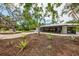 Landscaped front yard featuring native Florida landscaping and a long circular driveway at 5377 Palos Verdes Dr, Sarasota, FL 34231