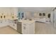 Modern kitchen showcasing stainless steel appliances, a central island with a sink, and a seamless flow to living space at 5377 Palos Verdes Dr, Sarasota, FL 34231