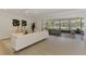 Spacious living room featuring modern tile floors and a sliding glass door to a screened lanai overlooking the water at 5377 Palos Verdes Dr, Sarasota, FL 34231