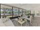 Relaxing screened-in lanai with waterfront view, stylish decor, and comfortable lounge furniture at 5377 Palos Verdes Dr, Sarasota, FL 34231