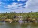 Stunning waterfront home surrounded by lush trees with a private dock on the water at 5377 Palos Verdes Dr, Sarasota, FL 34231