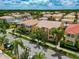 Beautiful aerial view of a vibrant neighborhood with lush landscaping, palm trees, and tile roofs at 5388 Davini St, Sarasota, FL 34238