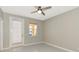 This is a bright bedroom with tile floors, a fan, a window and a door to the outside at 5388 Davini St, Sarasota, FL 34238