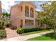 Inviting two-story townhome featuring a charming front porch and balcony, complemented by lush landscaping at 5388 Davini St, Sarasota, FL 34238