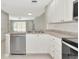Kitchen offers stainless dishwasher and sink, white cabinetry and tile floors at 5388 Davini St, Sarasota, FL 34238