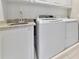 Modern laundry room featuring a granite countertop, sink, washer, and dryer at 5388 Davini St, Sarasota, FL 34238