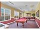 Bright game room with pool table, game table, and natural light from multiple windows at 5531 Rosehill Rd # 204, Sarasota, FL 34233