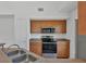 A cozy kitchen design with wooden cabinets, updated appliances, and solid surface countertops at 5531 Rosehill Rd # 204, Sarasota, FL 34233